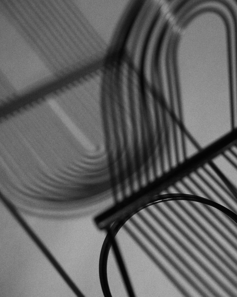 Swing chair — silhouette and shadow detail, black sprung steel.