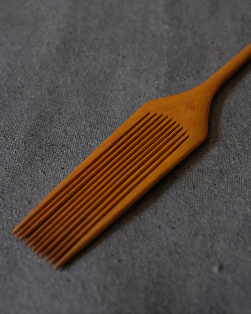 Close-up of fine teeth on Japanese maple wood comb