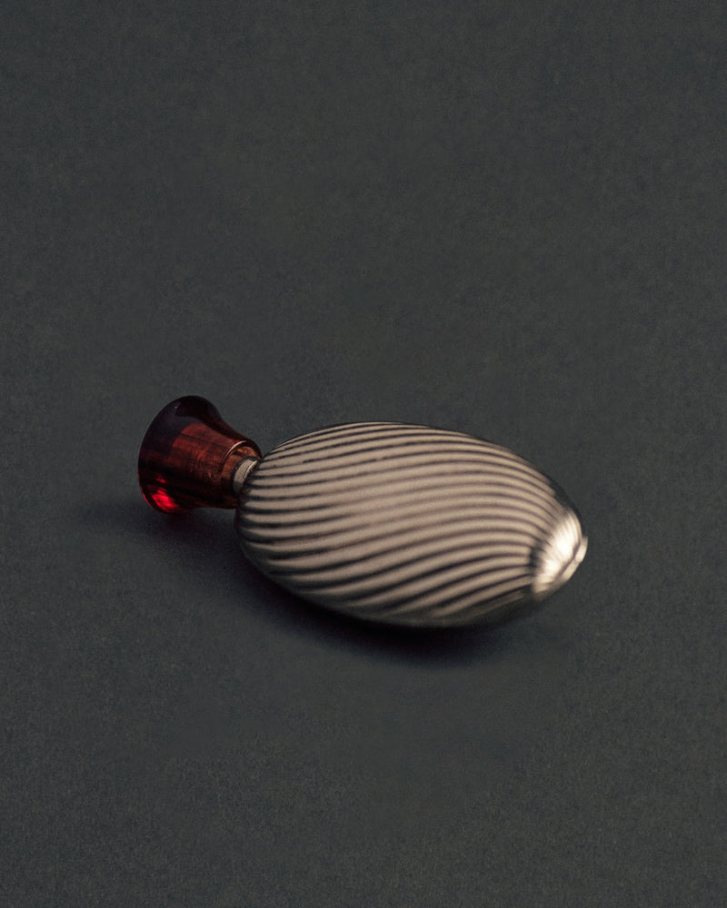 Vintage sterling silver perfume bottle, c.1930s — angled view showing ribbed surface and cap.